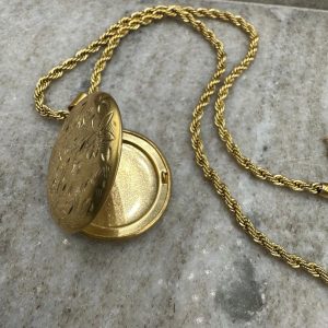 Μεταγιόν ανοιγόμενο με χάραξη εξωτερικά με σχέδια vintage λουλουδιών και ιδιαίτερη στριφογυριστή αλυσίδα. Αποτελεί ένα από τα πιο ιδιαίτερα κομμάτια της συλλογής μας , μιας και μπορεί να φιλοξενήσει στο εσωτερικό του την αγαπημένη σου φωτογραφία και συνεπώς μοναδικά συναισθήματα. Το ιδιαίτερο vintage μεταγιόν μας, περιμένει να εμπλουτίσει την κοσμηματοθήκη σου .