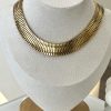 Ατσάλινο κολιέ σε γραμμικό σχέδιο  σε χρυσό χρώμα. Φοριέται μόνο του είτε σε συνδυασμό με άλλα κομμάτια για πιο εντυπωσιακά looks . Όπως και να το φορέσεις , το σίγουρο είναι ότι θα μαγνητίσεις τα βλέμματα .